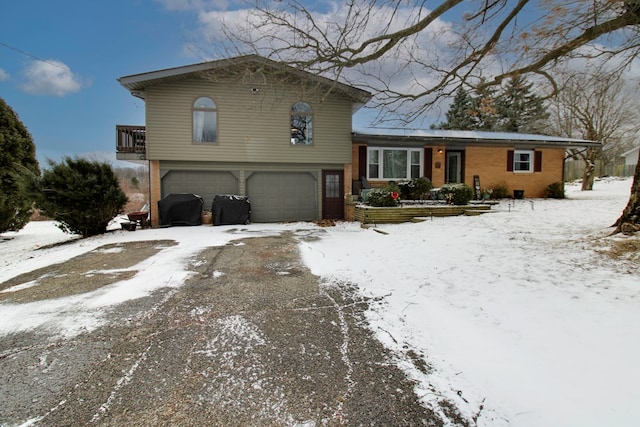 tri-level home with a garage and brick siding