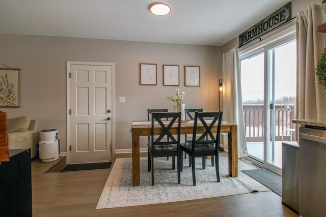 dining area with hardwood / wood-style flooring and baseboards