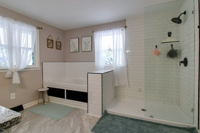 bathroom featuring a garden tub, plenty of natural light, and a shower stall