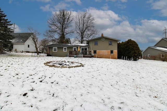 snow covered house with a wooden deck