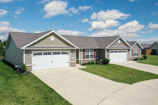 view of front of property featuring stone siding, an attached garage, concrete driveway, and a front lawn