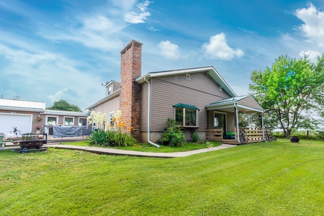 1163 Bowen Rd, Mansfield, OH 44903 - rear view of property with a chimney, a lawn, and an attached garage