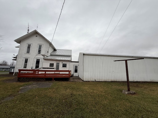 back of property featuring a lawn and a wooden deck