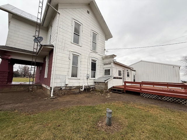 rear view of house with a deck and a lawn