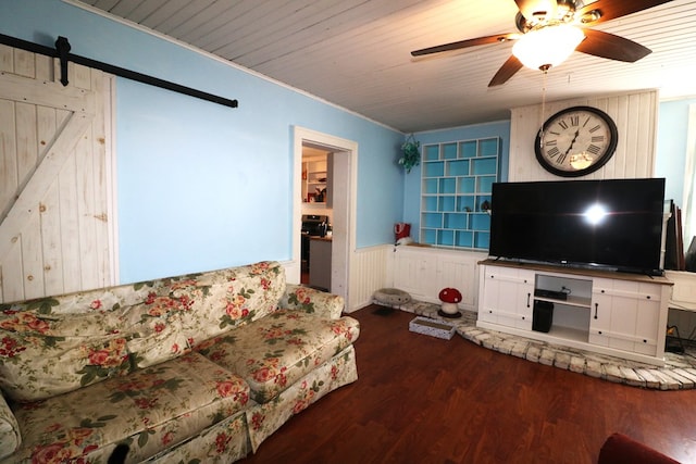 11914 State Route 269, Bellevue, OH 44811 - living area featuring a barn door, wooden walls, ceiling fan, a wainscoted wall, and dark wood-style floors