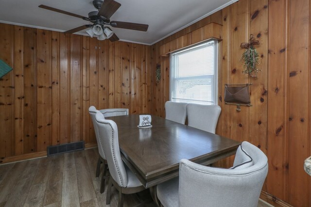 623 Bendle Ave, Shelby, OH 44875 - dining room with wood finished floors, ceiling fan, wood walls, crown molding, and baseboards