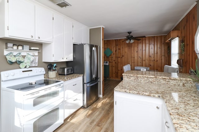 623 Bendle Ave, Shelby, OH 44875 - kitchen with double oven range, ceiling fan, light wood finished floors, freestanding refrigerator, and wood walls