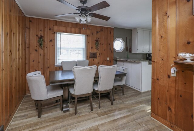 623 Bendle Ave, Shelby, OH 44875 - dining space with light wood finished floors, ceiling fan, wooden walls, and crown molding