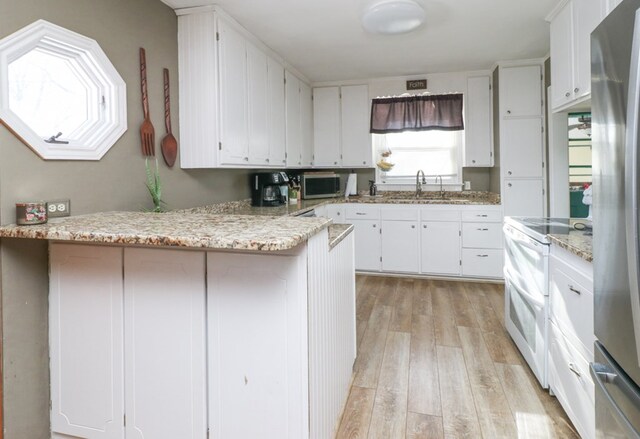 623 Bendle Ave, Shelby, OH 44875 - kitchen with stainless steel appliances, light wood-style floors, a peninsula, and white cabinets