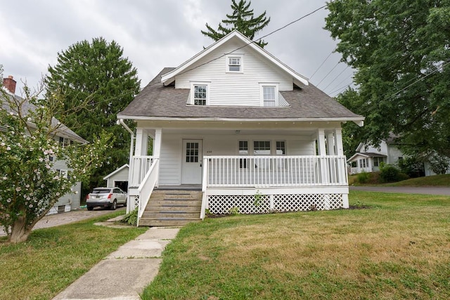 bungalow-style home with covered porch and a front yard