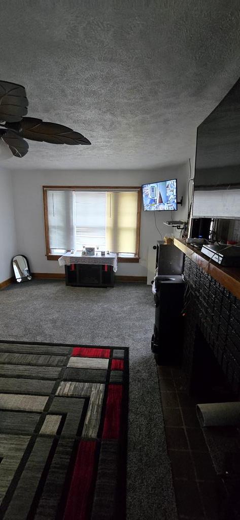 kitchen featuring ceiling fan, stainless steel appliances, a textured ceiling, and dark wood-type flooring