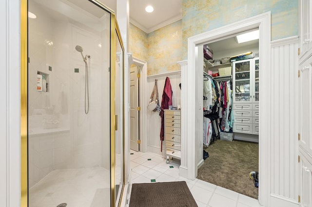 full bathroom with wallpapered walls, a spacious closet, a stall shower, tile patterned flooring, and wainscoting