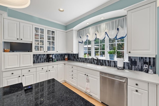 kitchen with decorative backsplash, a sink, crown molding, and stainless steel dishwasher