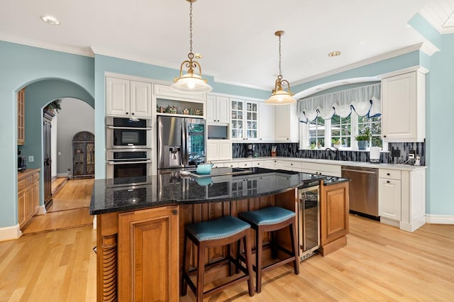 kitchen with wine cooler, a center island, appliances with stainless steel finishes, and tasteful backsplash