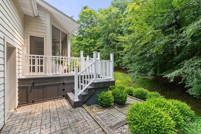 view of patio / terrace featuring a hot tub, a sunroom, and a wooden deck