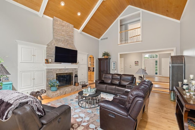 living area with wood finished floors, wooden ceiling, a stone fireplace, and visible vents