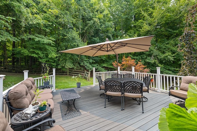 deck with outdoor dining area and a yard