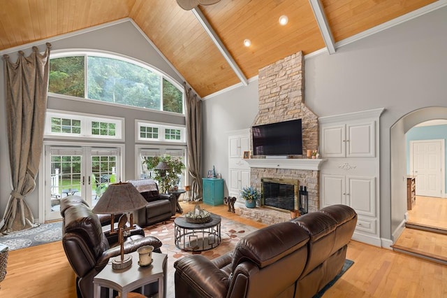 living room with light wood-type flooring, high vaulted ceiling, wood ceiling, arched walkways, and a fireplace