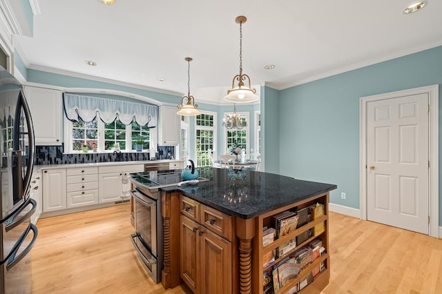kitchen featuring stainless steel range with electric cooktop, white cabinets, ornamental molding, and freestanding refrigerator