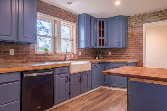 1676 Old Delaware Rd, Mount Vernon, OH 43050 - kitchen with butcher block countertops, dishwasher, brick wall, glass insert cabinets, and light wood-style flooring