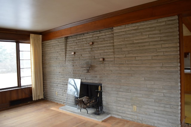 unfurnished living room with hardwood / wood-style flooring, crown molding, and a healthy amount of sunlight