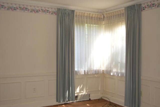 empty room featuring crown molding and wood-type flooring