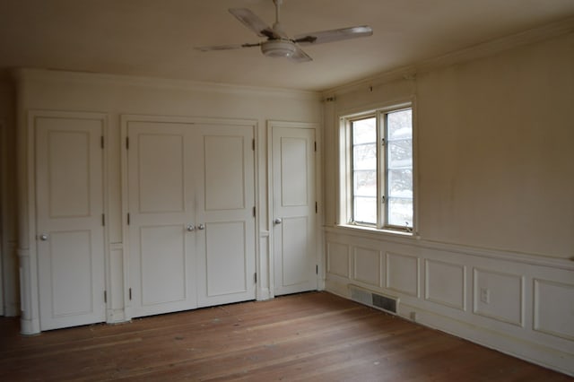 unfurnished bedroom with ceiling fan, wood-type flooring, and ornamental molding