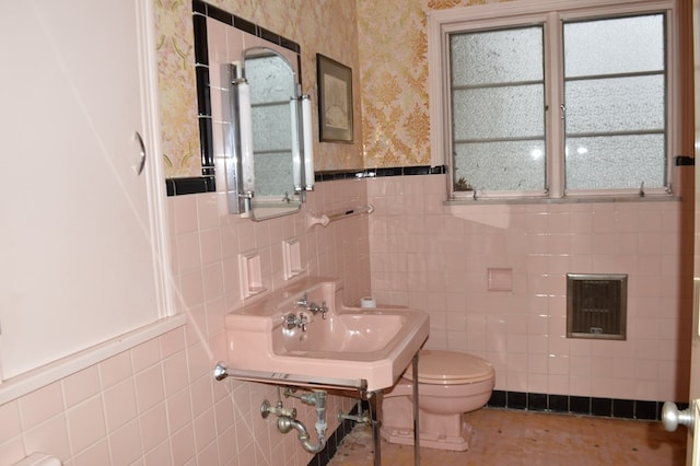 bathroom featuring sink, tile patterned flooring, toilet, and tile walls