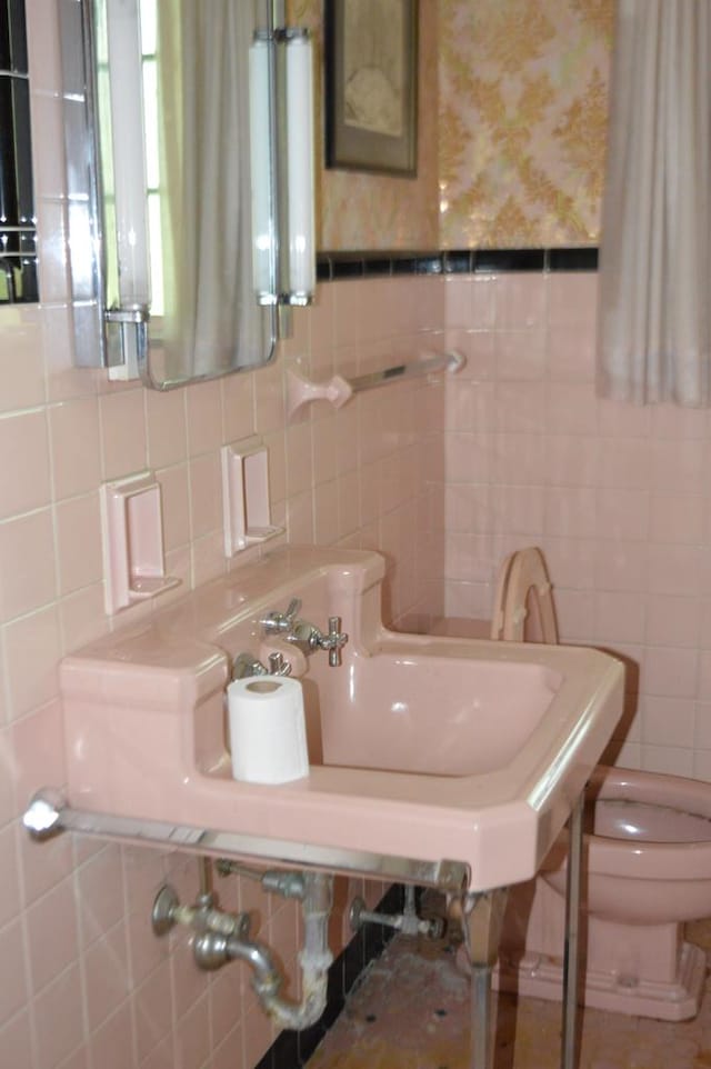 bathroom with tile walls and toilet