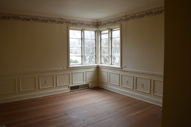 empty room featuring light hardwood / wood-style flooring and ornamental molding