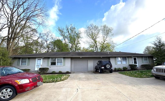 ranch-style home with concrete driveway and an attached garage