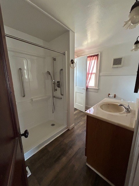 bathroom featuring vanity, hardwood / wood-style flooring, and walk in shower