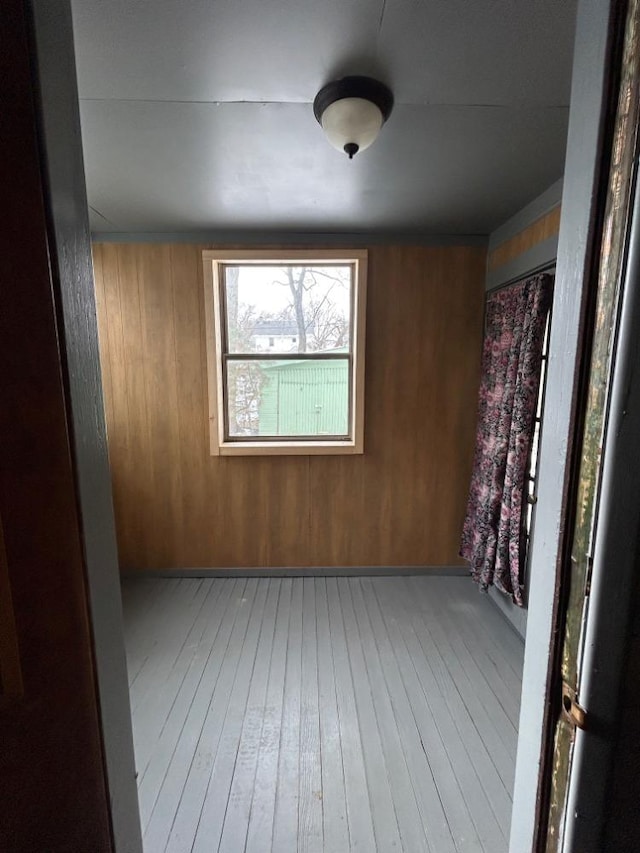 unfurnished room featuring wood-type flooring and wood walls