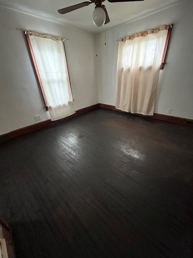 empty room with ceiling fan and dark hardwood / wood-style floors