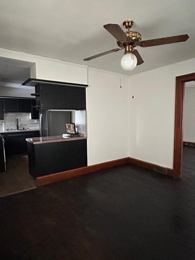 kitchen featuring tasteful backsplash, ceiling fan, refrigerator, and sink