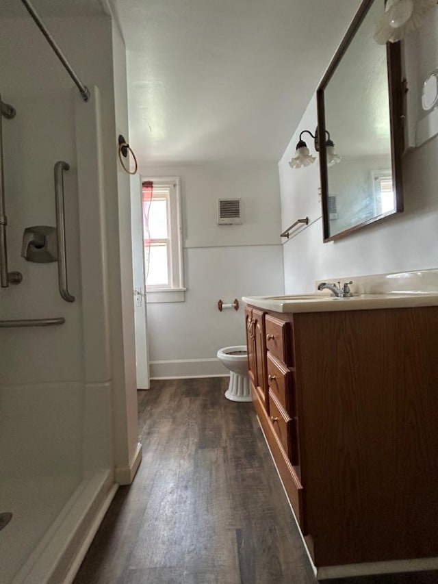 bathroom with vanity, a shower, hardwood / wood-style floors, and toilet