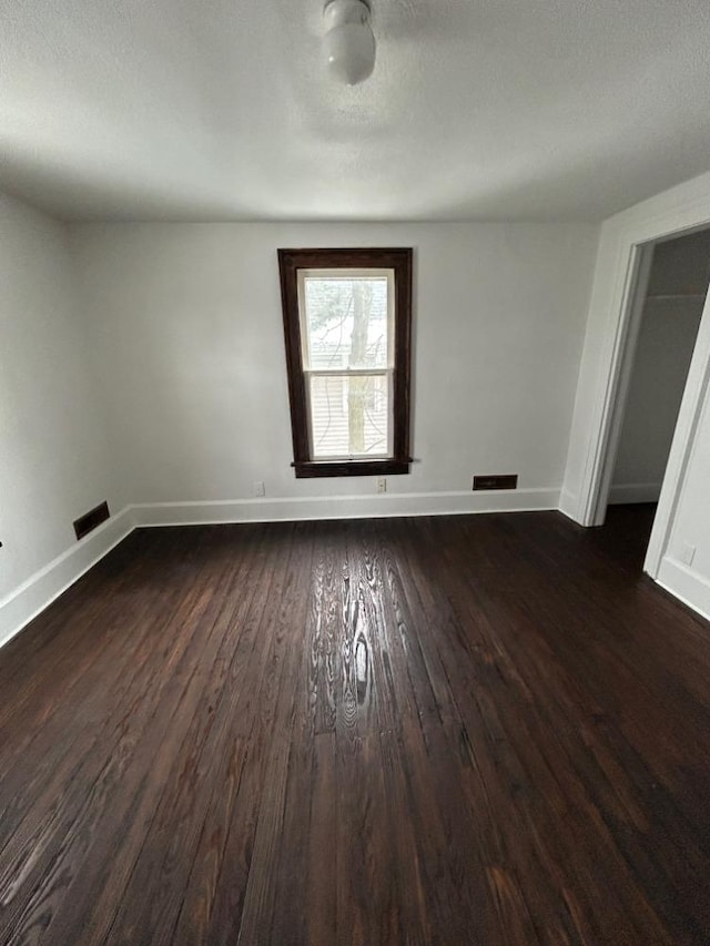 spare room with dark wood-type flooring