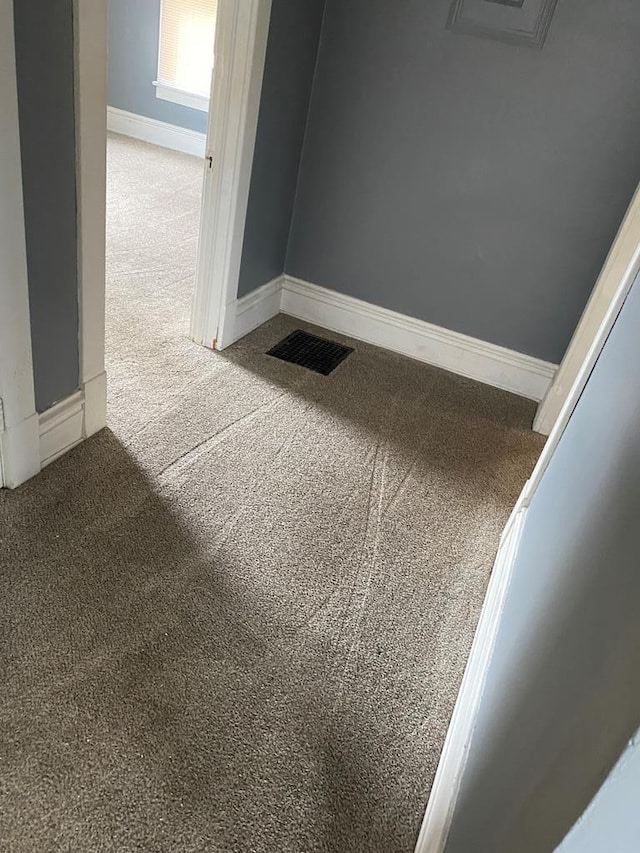 interior details featuring baseboards, visible vents, and carpet floors