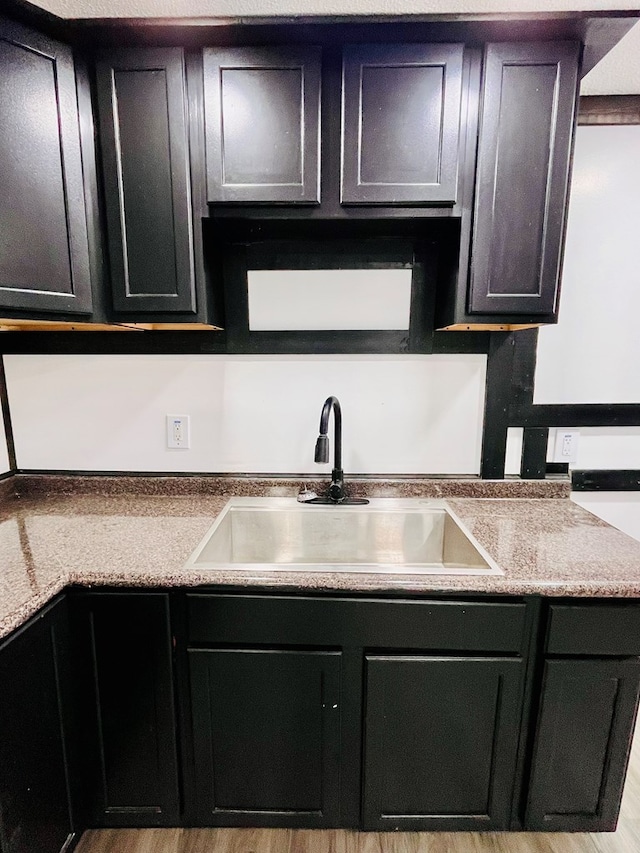 328 Newman St, Mansfield, OH 44902 - kitchen featuring dark cabinetry, wood finished floors, and a sink