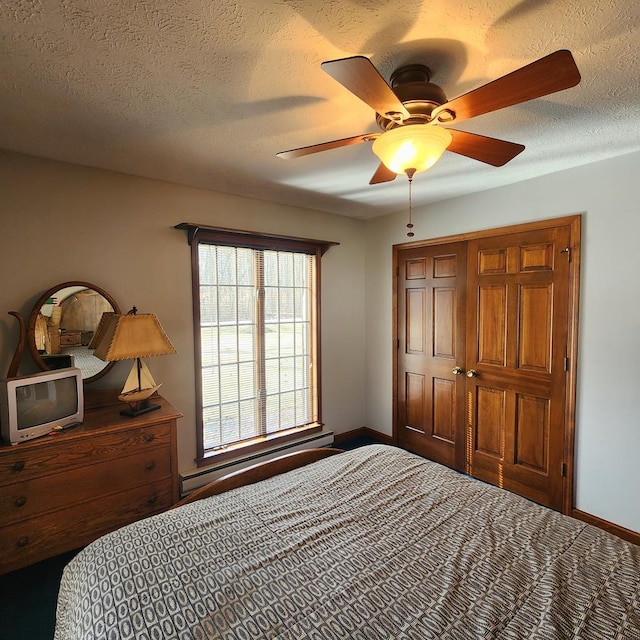 bedroom with a baseboard heating unit, ceiling fan, a textured ceiling, and baseboards