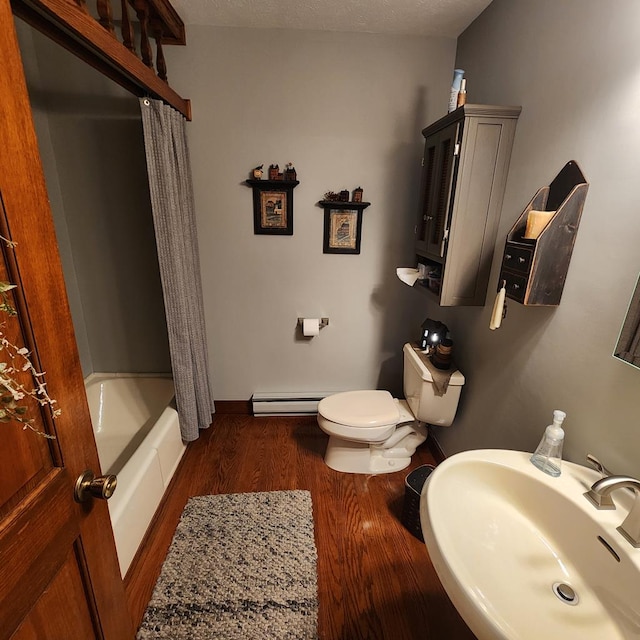 full bathroom featuring toilet, shower / tub combo, wood finished floors, a sink, and baseboard heating