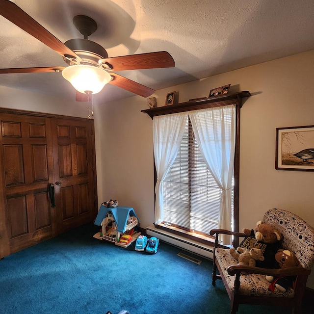 game room with carpet, ceiling fan, and a textured ceiling