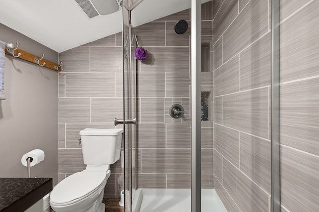 bathroom with vaulted ceiling, toilet, an enclosed shower, and tile walls