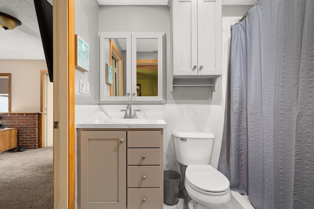 bathroom featuring vanity, toilet, and a textured ceiling