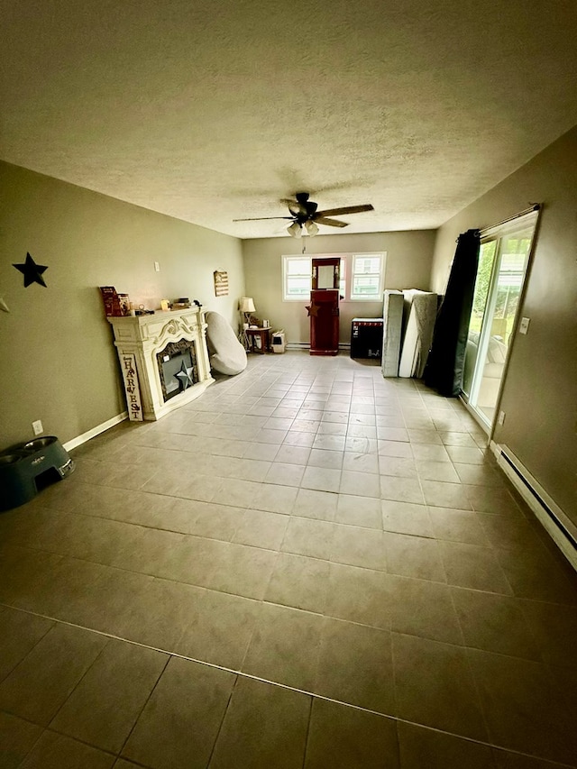 950 Woodbine St, Willard, OH 44890 - unfurnished living room with ceiling fan, tile patterned flooring, a textured ceiling, and baseboards