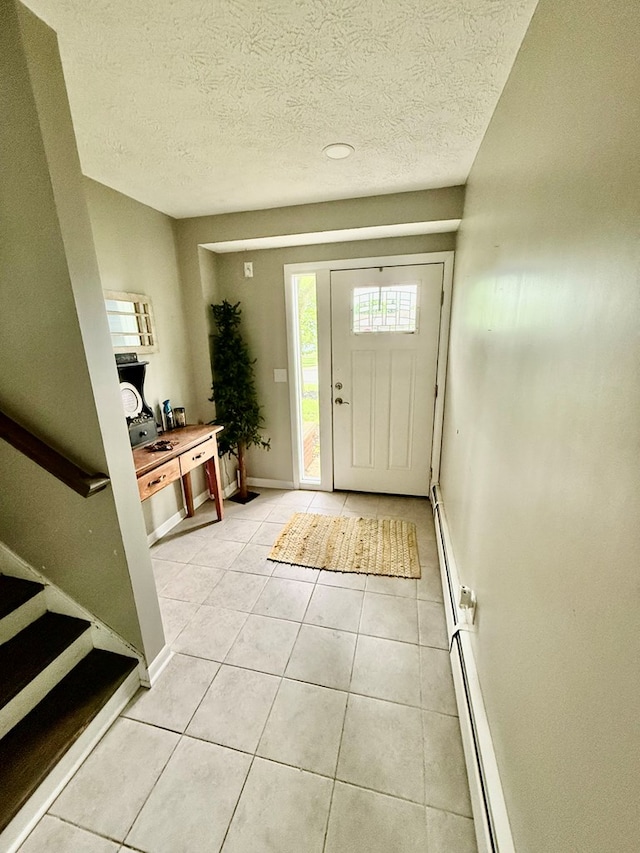 950 Woodbine St, Willard, OH 44890 - foyer entrance with light tile patterned floors, a textured ceiling, and baseboards