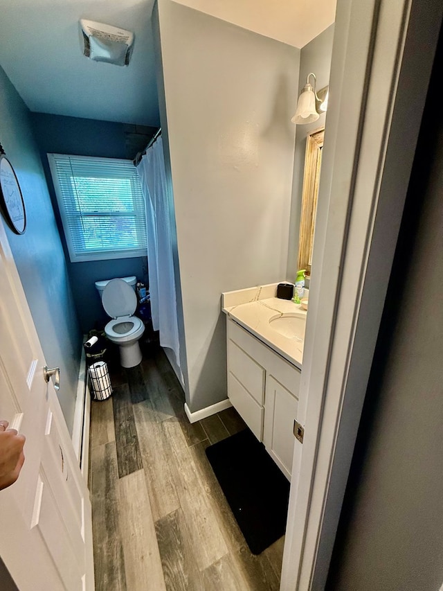 950 Woodbine St, Willard, OH 44890 - full bath with toilet, wood finished floors, vanity, a shower with shower curtain, and baseboards