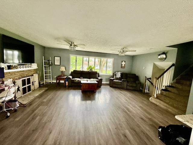 950 Woodbine St, Willard, OH 44890 - living room featuring dark wood-style flooring, a textured ceiling, ceiling fan, stairway, and a baseboard heating unit