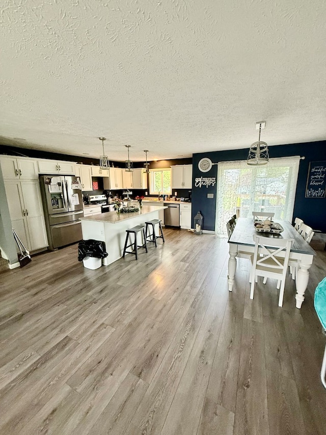 950 Woodbine St, Willard, OH 44890 - dining area featuring a textured ceiling, wood finished floors, and baseboards