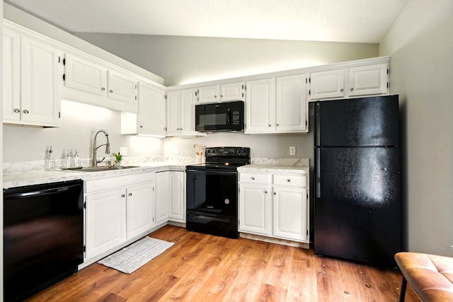 1696 Riva Rdg, Mansfield, OH 44904 - kitchen with black appliances, vaulted ceiling, white cabinets, light wood finished floors, and light stone countertops